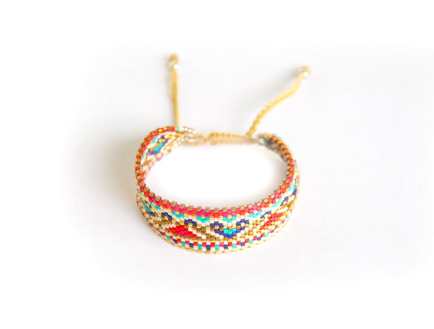 Pulsera Miyuki grande lineas doradas y grecas rojo azul