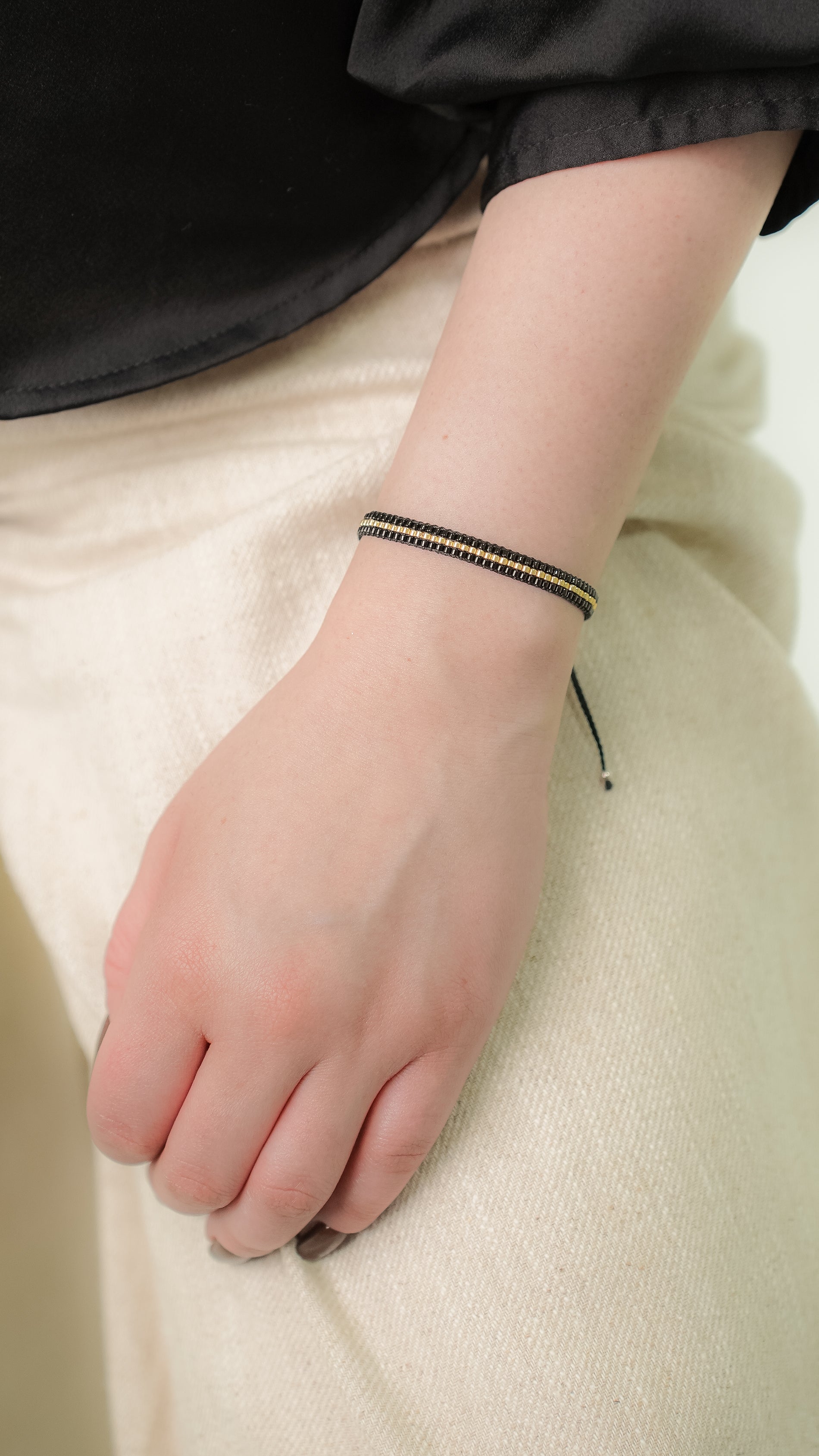 Pulsera MIYUKI 3 lineas negro centro dorado
