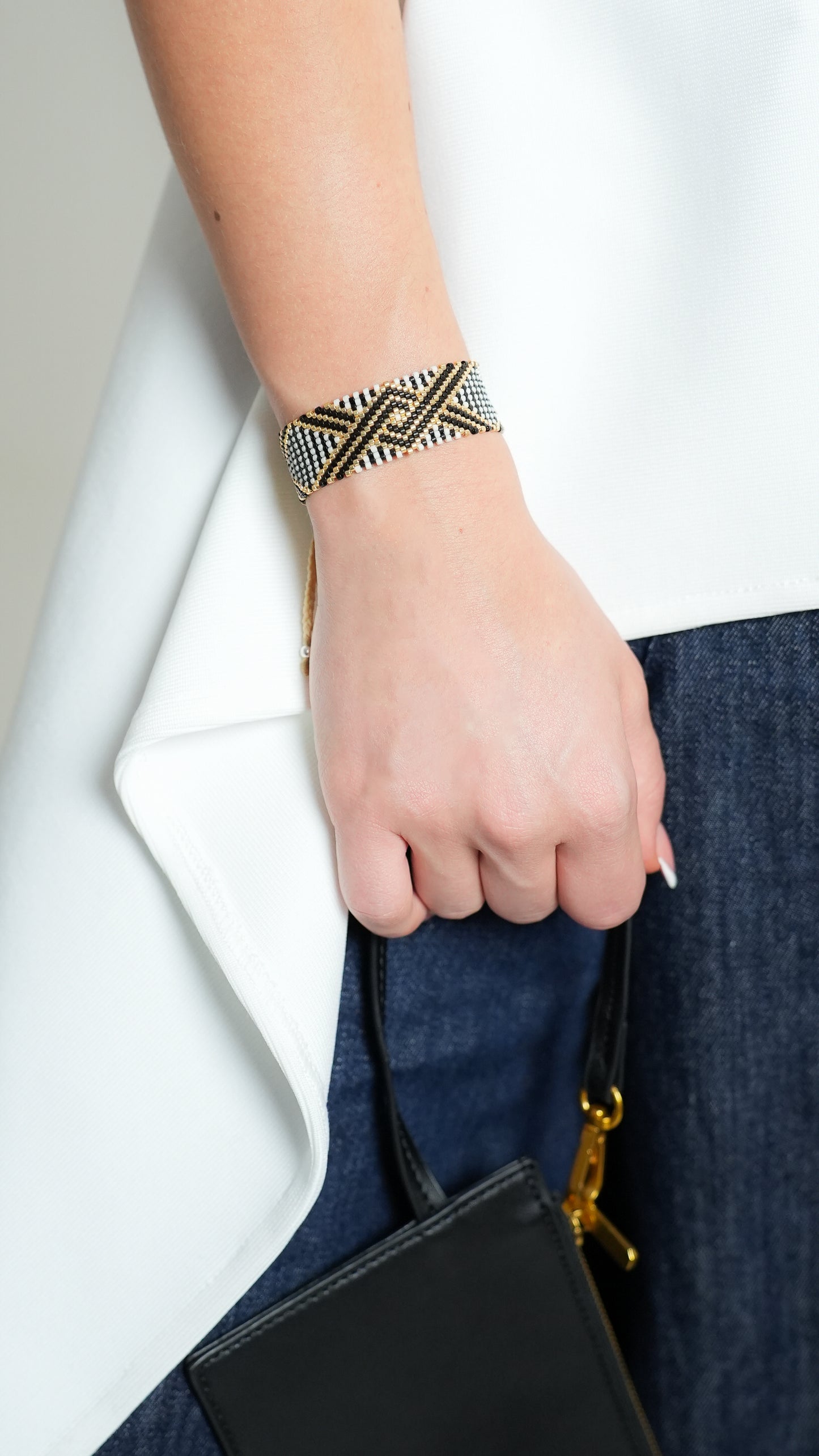 Pulsera Miyuki grande blanca lineas cruzadas negro dorado