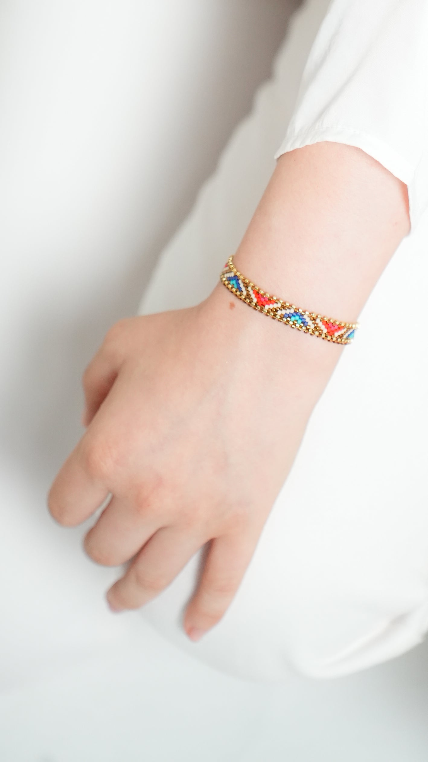 Pulsera Miyuki chica lineas doradas y triangulos rojo azul