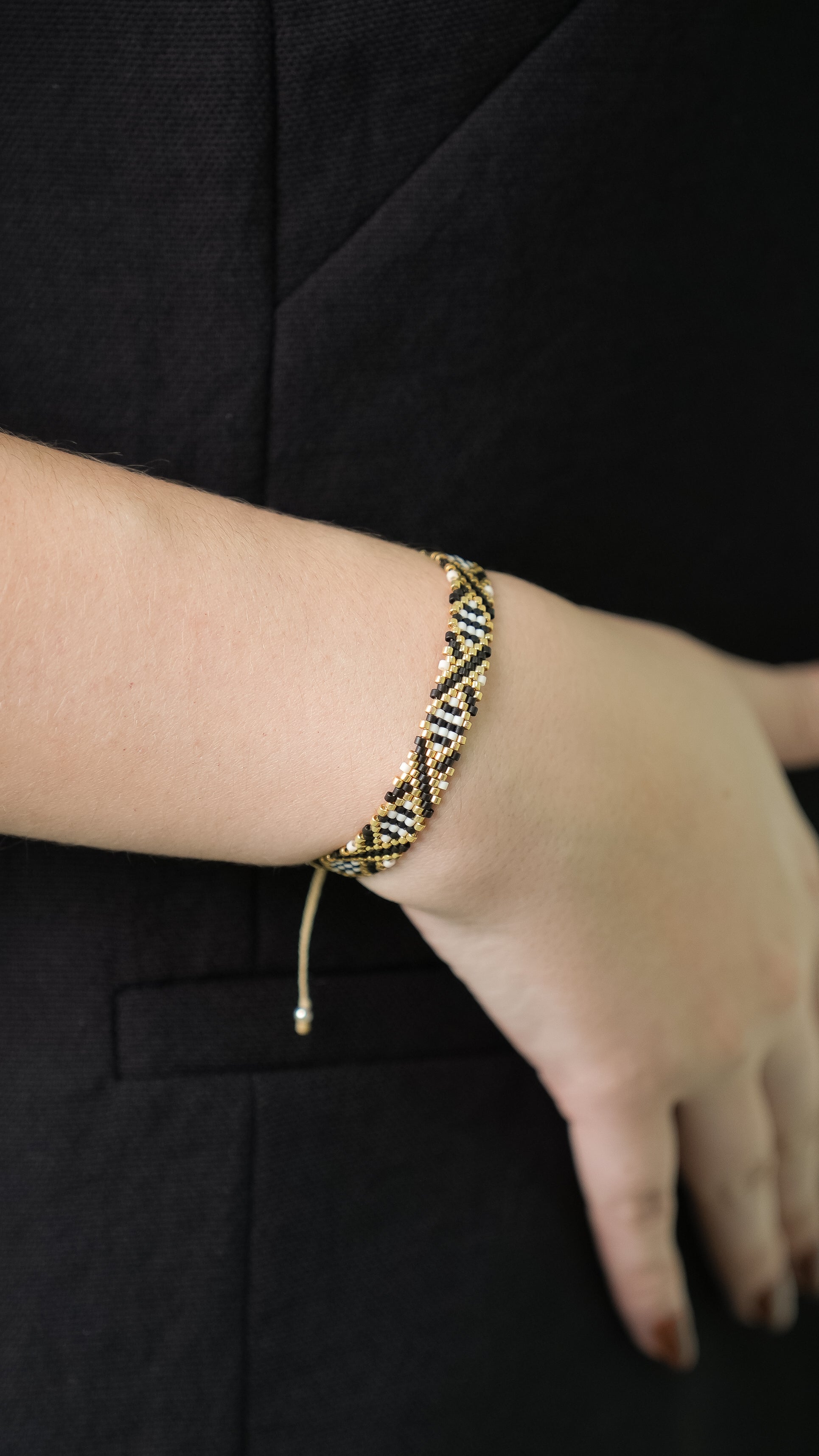 Pulsera Miyuki chica blanca lineas cruzadas negro dorado