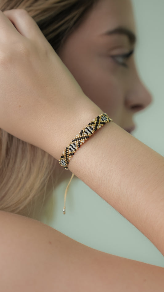 Pulsera Miyuki chica blanca lineas cruzadas negro dorado