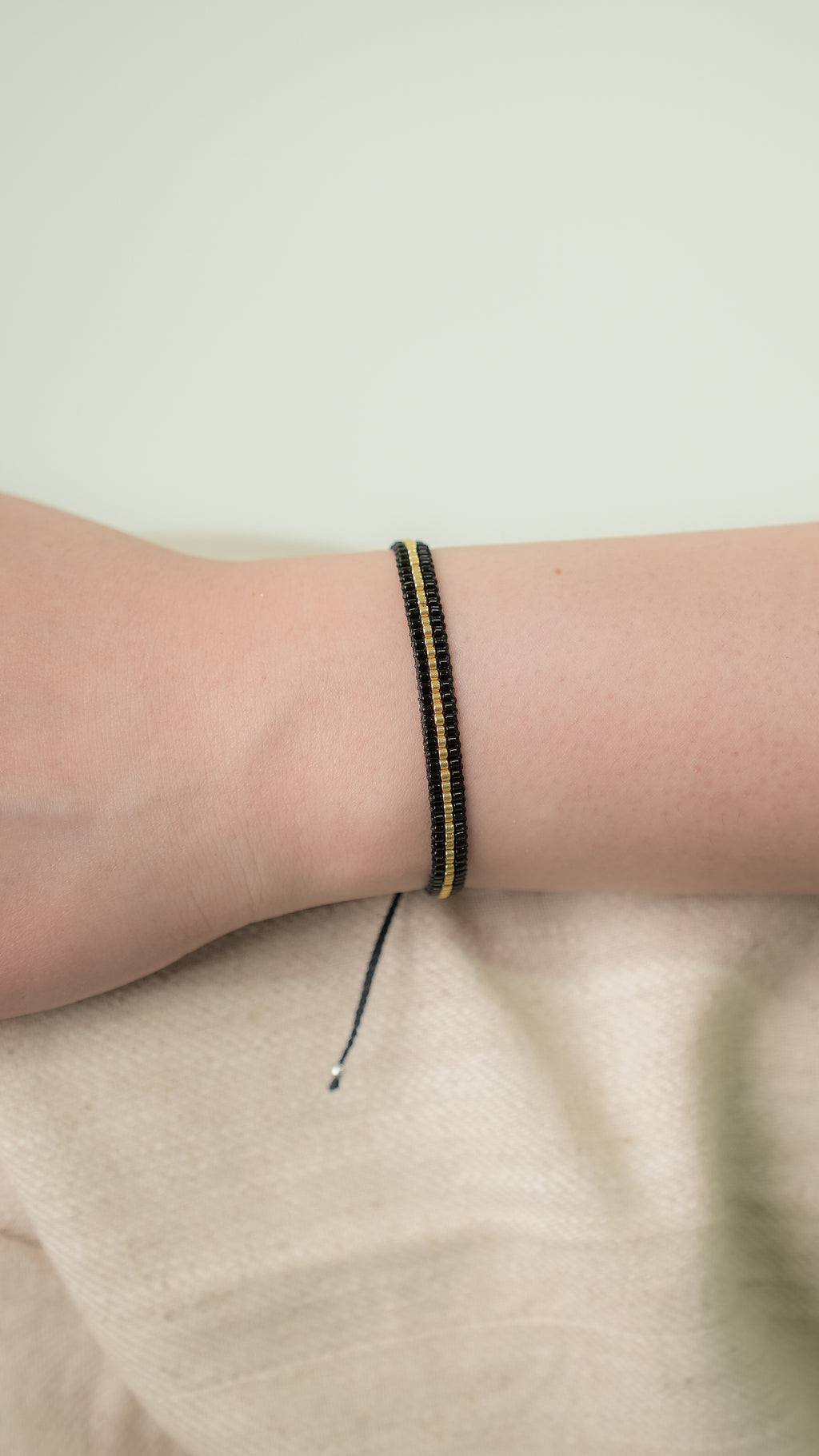Pulsera MIYUKI 3 lineas negro centro dorado