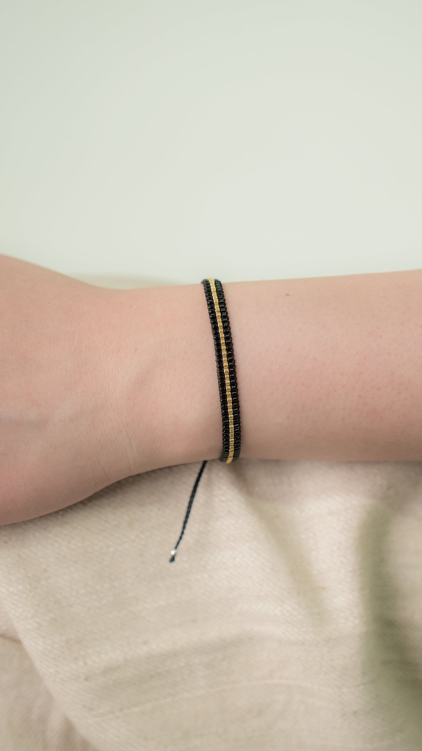 Pulsera MIYUKI 3 lineas negro centro dorado